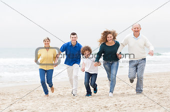 Happy family jugging at the beach