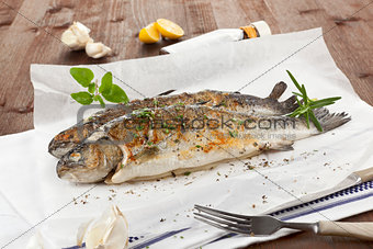 Two grilled trouts with fresh herbs.