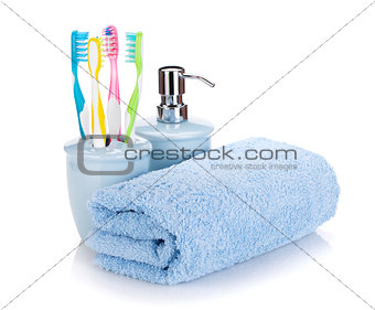 Four colorful toothbrushes, liquid soap and towel