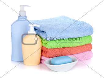 Cosmetics bottles, soap and colored towels