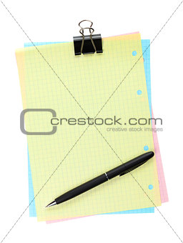 Colorful lined office paper with clip and pen