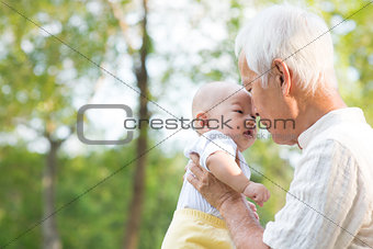 Asian grandfather kissing grandson