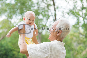 Asian grandfather carrying grandson