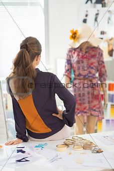 Fashion designer looking on mannequin. rear view