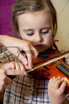preschool child learning violin playing