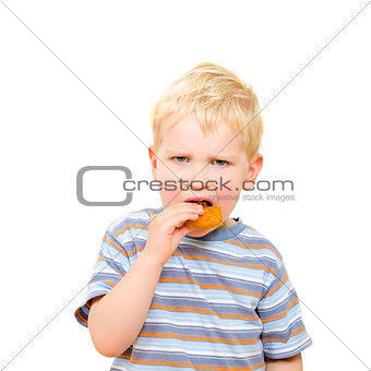 Cute little boy eating delicious cookie isolated on white