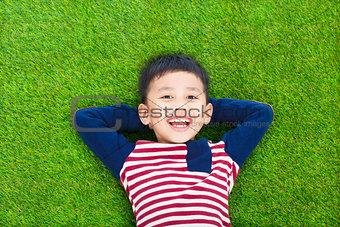 smiling kid lying and holding his head