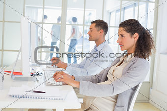 Casual pregnant businesswoman working at desk