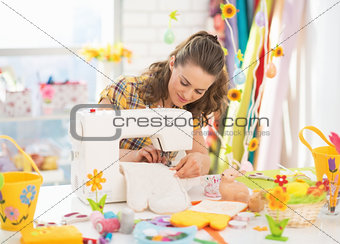 Young woman making easter pot holder mitts in studio