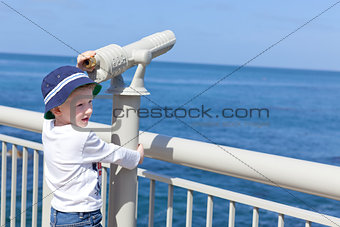 boy using seaside binoculars