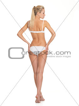Full length portrait of young woman in lingerie. rear view