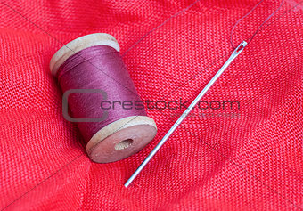 needle and thread on a red background