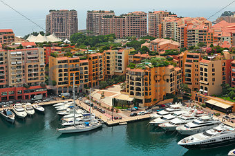 Marina with yachts and boats between contemporary buildings in Monte Carlo, Monaco (view from above).
