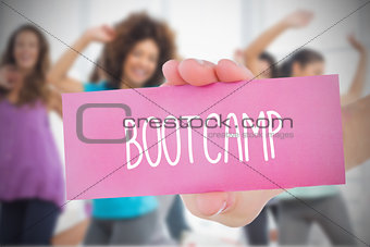 Woman holding pink card saying bootcamp