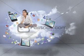 Composite image of businesswoman sitting cross legged thinking