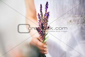 Beautiful bride holding field flowers