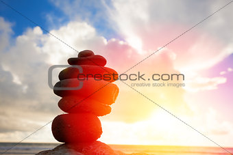 stones stack pyramid on a beach with sunset background 