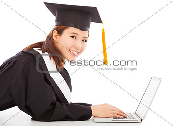 smiling female graduation lying on floor with laptop