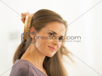 Young woman combing hair