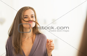 Happy young woman playing with hair
