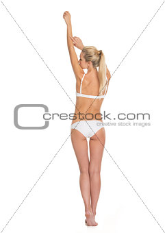 Full length portrait of young woman in lingerie. rear view