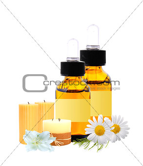 bottles with essence oil, candles and chamomiles