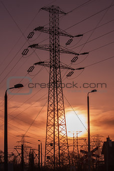 High voltage pole with lanterns at sunset
