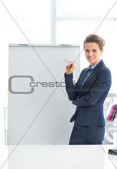 Portrait of smiling business woman near flipchart