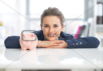 Portrait of happy business woman with piggy bank