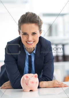 Portrait of smiling business woman with piggy bank