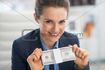 Portrait of happy business woman showing money pack