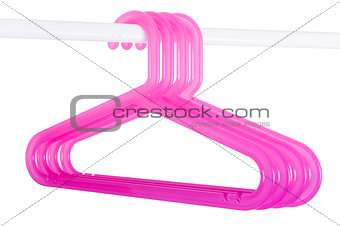 Pink hangers on a rod isolated on white
