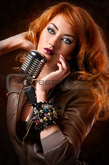 Beautiful redhead girl with retro microphone