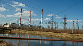 Factory pipes and high voltage power lines against the blue sky 