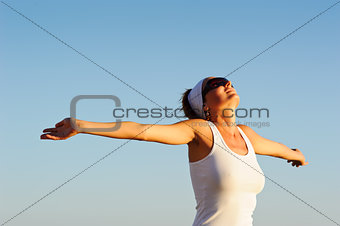 girl with arms raised towards the sky