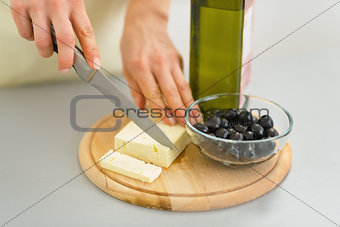 Closeup on young housewife cutting cheese