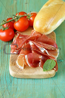 parma ham (jamon) sliced on a wooden board