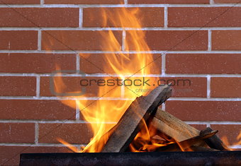 burning wood in a brazier on the brick wall background