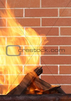 burning wood in a brazier on the brick wall background