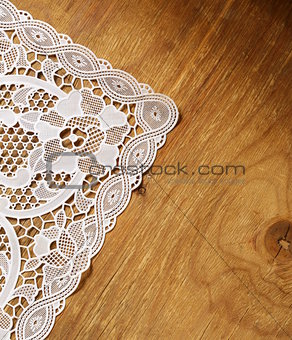 old wooden background with white lace napkin