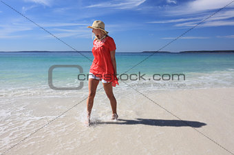 Happy woman splashing feet at the beach