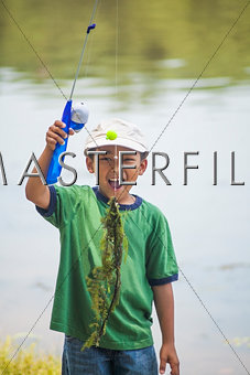 Boy with fishing line full of pondweed