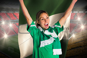 Cheering football fan in green jersey holding nigeria flag