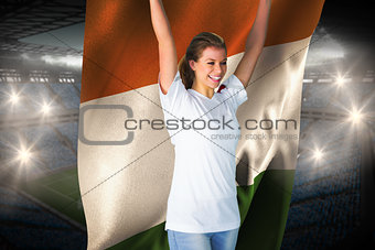Pretty football fan in white cheering holding ivory coast flag
