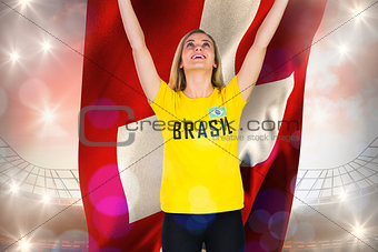 Excited football fan in brasil tshirt holding swiss flag