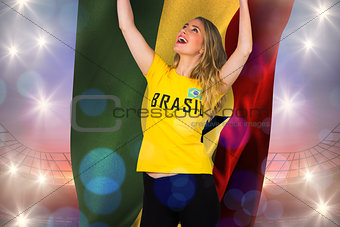 Excited football fan in brasil tshirt holding ghana flag