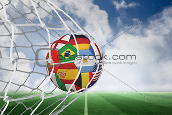 Football in multi national colours at back of net