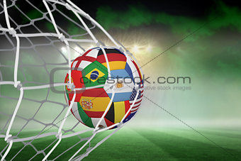 Football in multi national colours at back of net