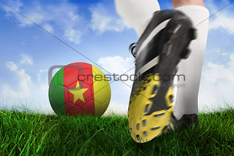 Close up of football boot kicking cameroon ball