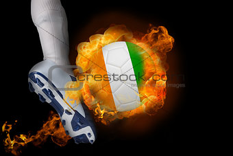 Football player kicking flaming ivory coast ball